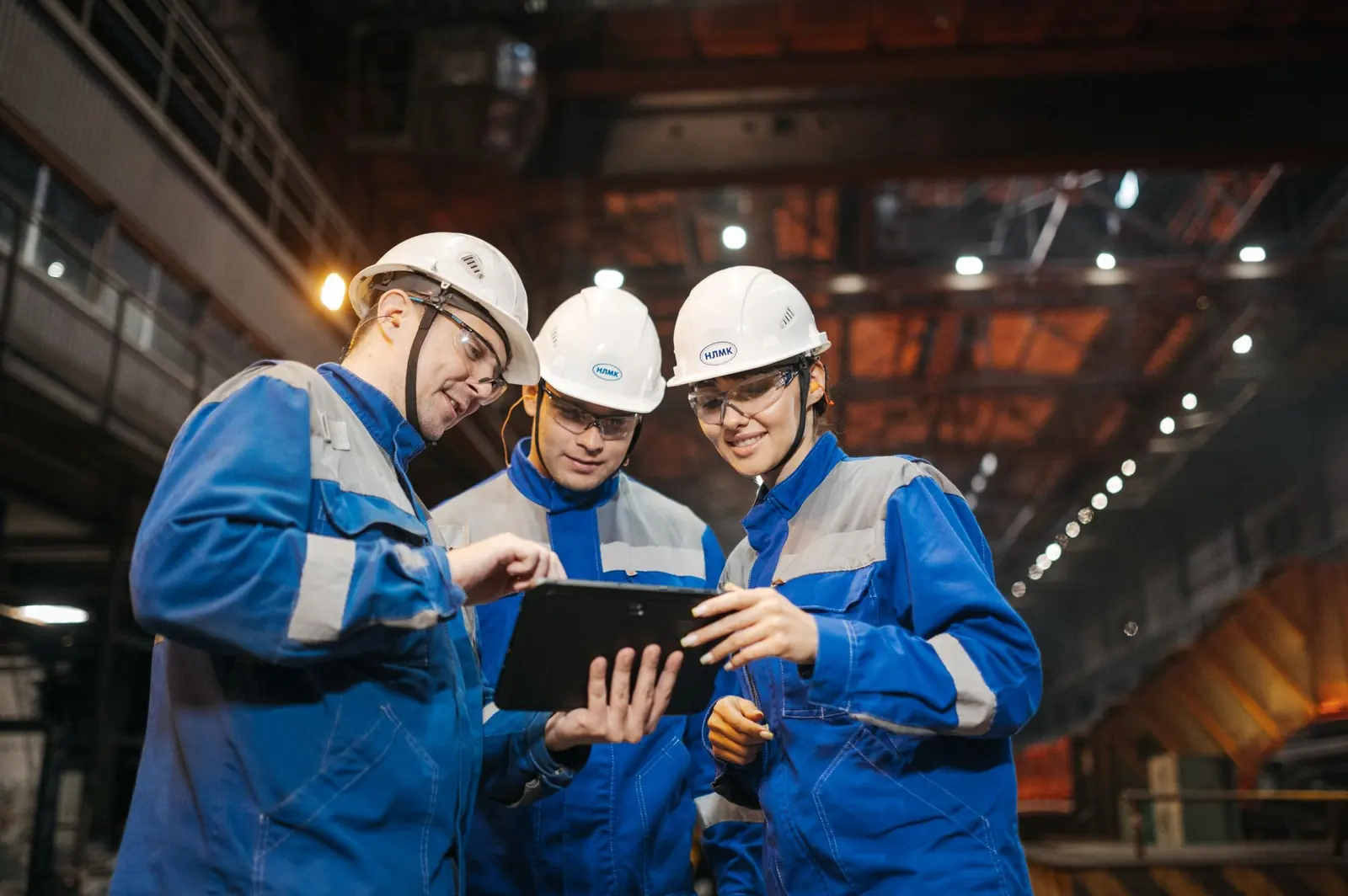 Engineers reviewing data on a tablet inside an industrial plant