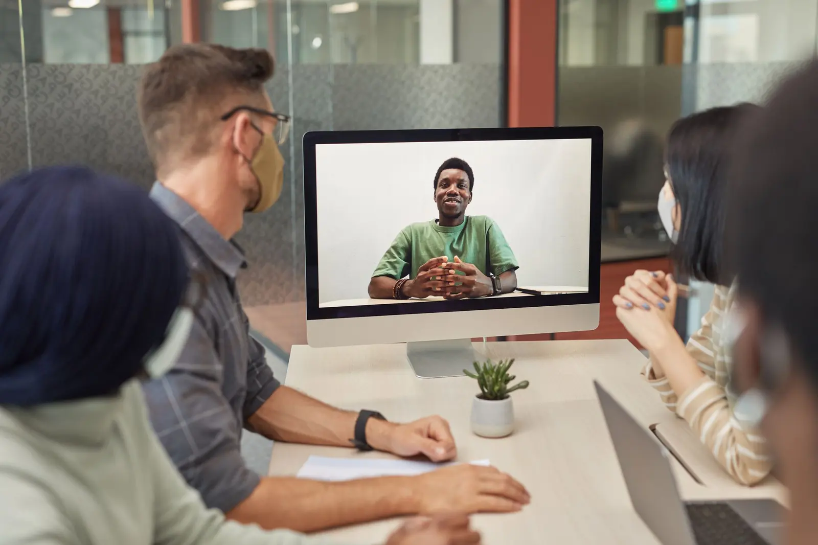 A distributed team meeting over video from a conference room