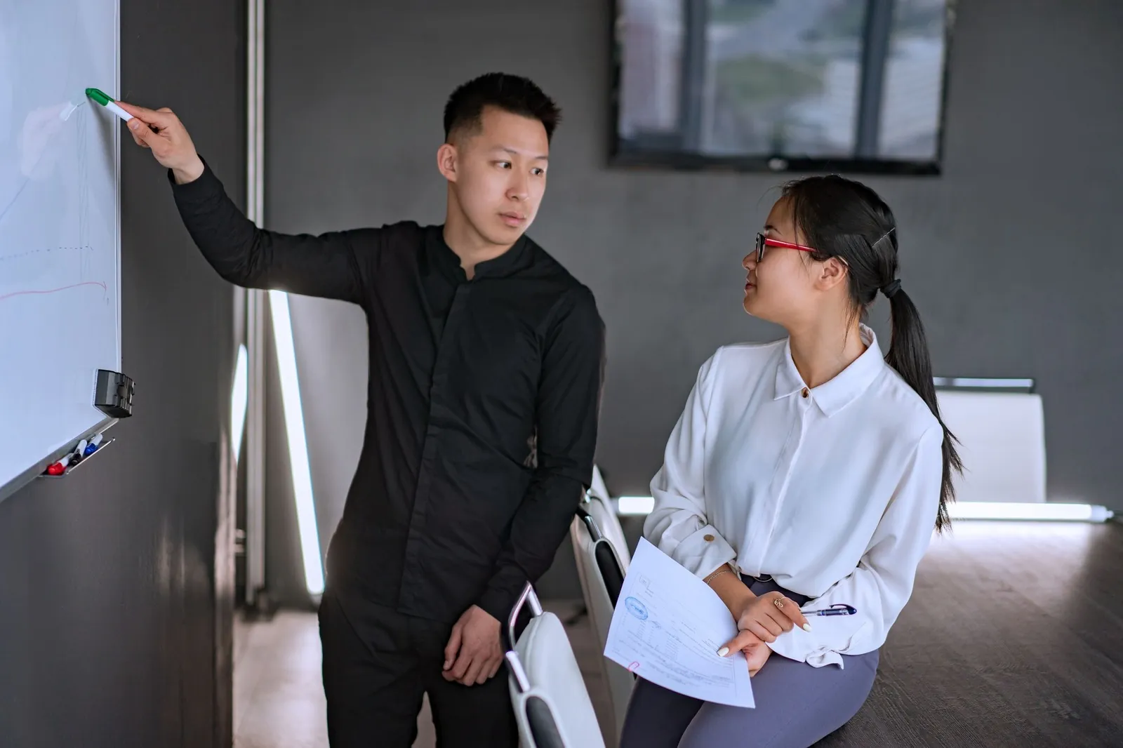 An architect sketching a plan on a whiteboard