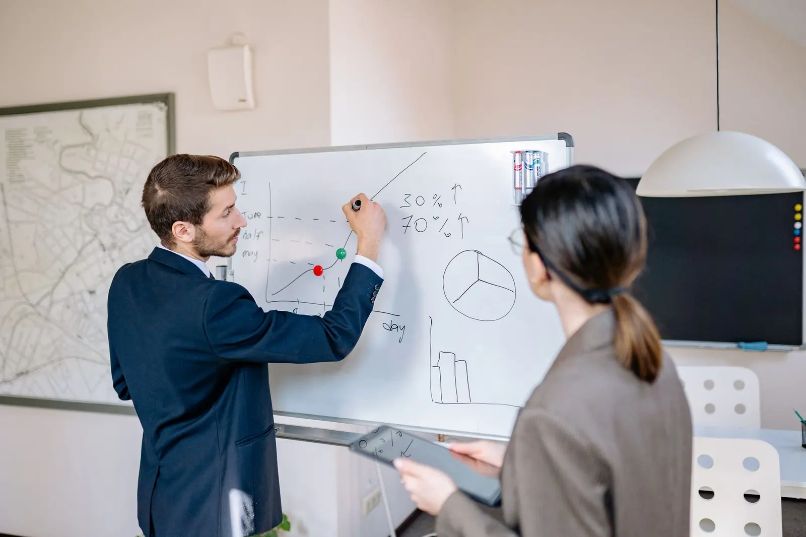 An architect sketching a plan on a whiteboard