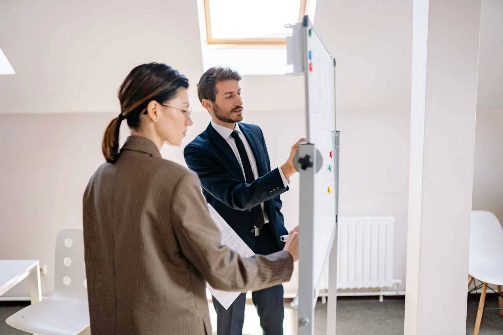 Two consultants designing a system on a whiteboard