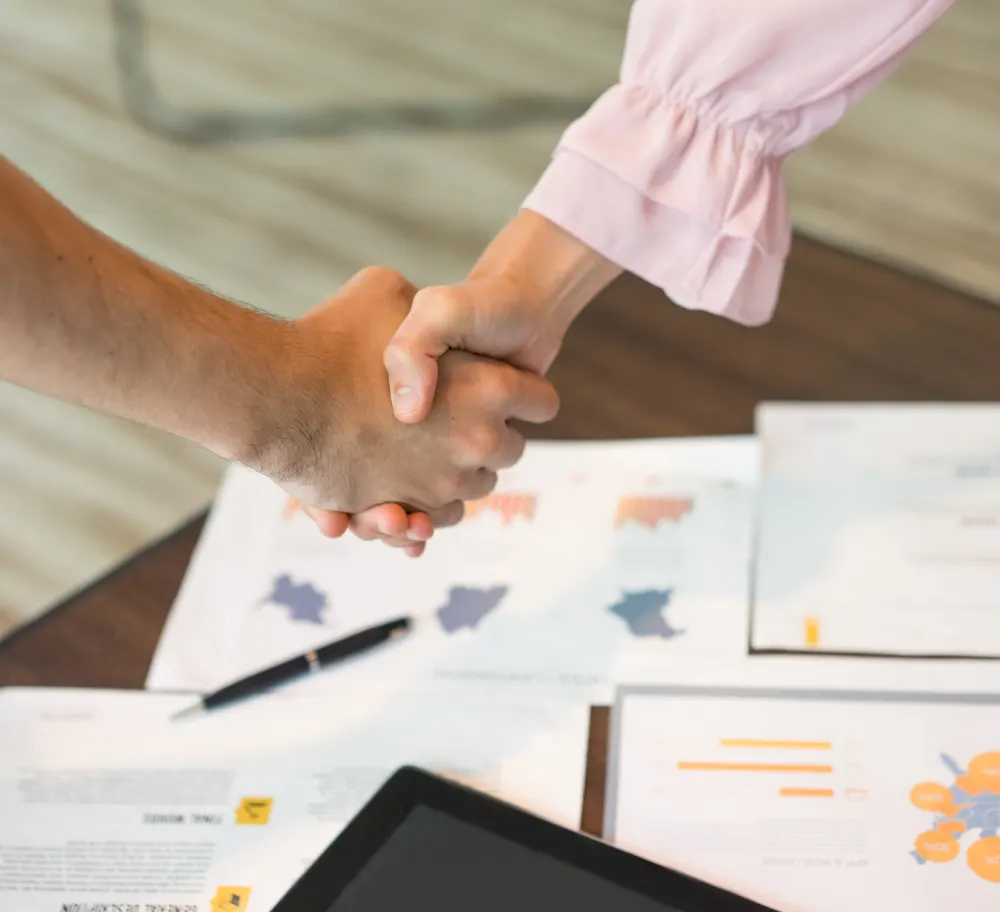 close-up-male-female-hands-handshake-documents